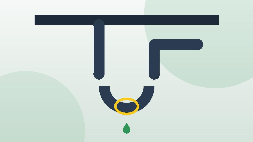 U-shaped trap beneath a kitchen sink being unscrewed for cleaning